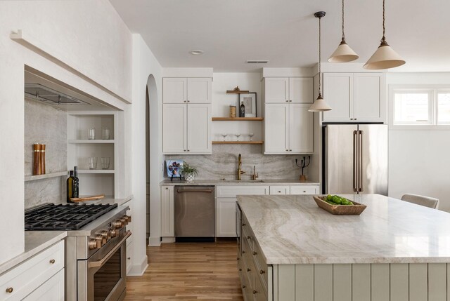 322 Starling Ln, Franklin, TN 37064 - kitchen featuring high quality appliances, open shelves, light wood-style flooring, a center island, and decorative backsplash
