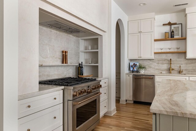 322 Starling Ln, Franklin, TN 37064 - kitchen with stainless steel appliances, open shelves, backsplash, light wood-type flooring, and light stone countertops