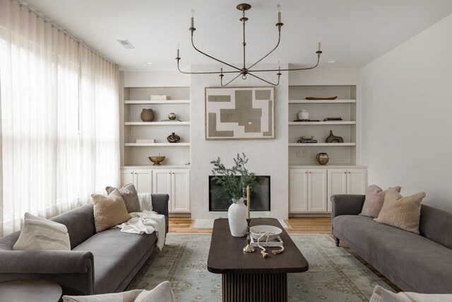 322 Starling Ln, Franklin, TN 37064 - living room featuring light wood-style flooring, a chandelier, and built in features