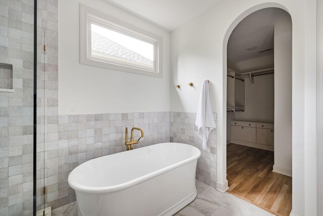 322 Starling Ln, Franklin, TN 37064 - full bathroom with a walk in closet, a freestanding tub, tile walls, and a wainscoted wall