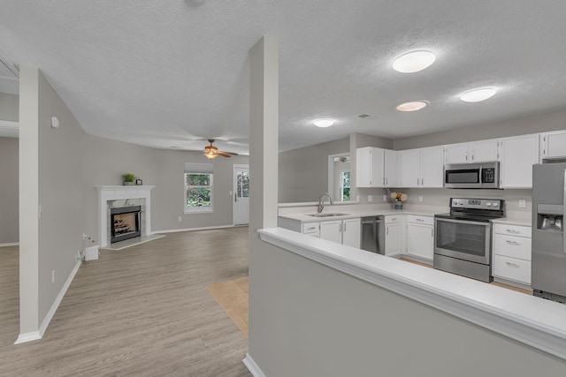 7352 Hidden Lake Cir, Fairview, TN 37062 - kitchen with appliances with stainless steel finishes, light wood finished floors, light countertops, a textured ceiling, and ceiling fan