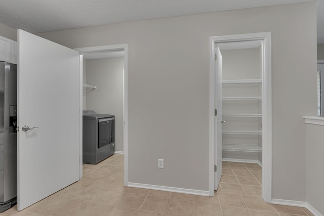 7352 Hidden Lake Cir, Fairview, TN 37062 - unfurnished bedroom featuring washer / dryer, stainless steel fridge, a spacious closet, light tile patterned floors, and a closet