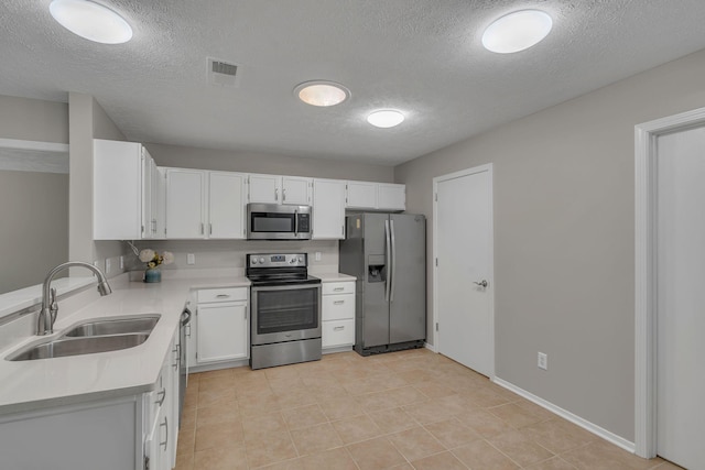 7352 Hidden Lake Cir, Fairview, TN 37062 - kitchen featuring appliances with stainless steel finishes, a textured ceiling, light countertops, white cabinetry, and light tile patterned flooring