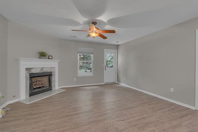 7352 Hidden Lake Cir, Fairview, TN 37062 - unfurnished living room with a high end fireplace, wood finished floors, and ceiling fan