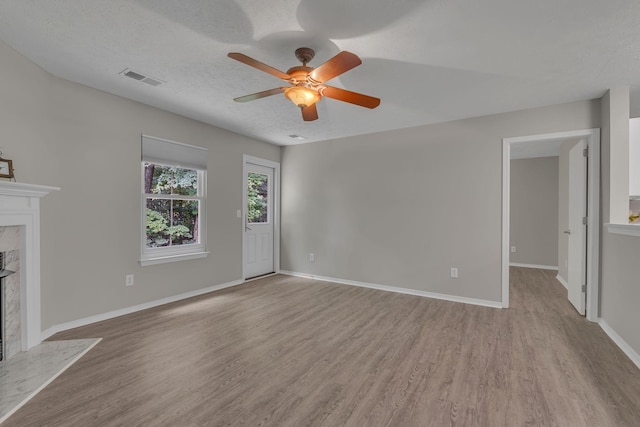 7352 Hidden Lake Cir, Fairview, TN 37062 - unfurnished living room featuring a premium fireplace, light wood-style floors, and ceiling fan