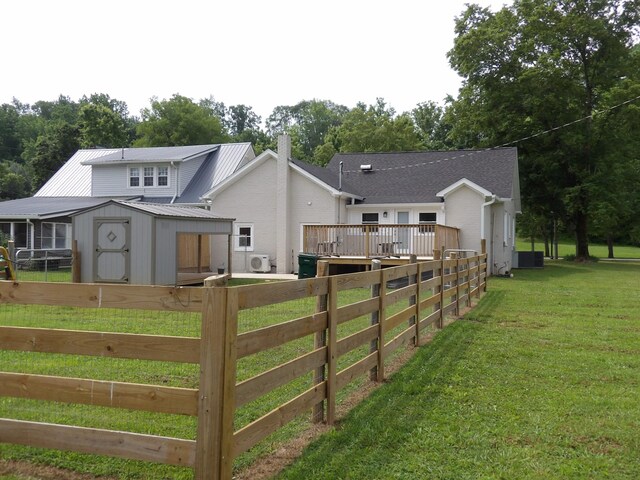413 E Main St, Waverly, TN 37185 - rear view of house with a storage unit, a metal roof, a wooden deck, and a chimney