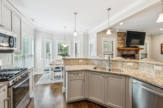 146 Island Way, Winchester, TN 37398 - kitchen featuring stainless steel appliances, dark wood finished floors, a stone fireplace, light stone counters, and decorative light fixtures