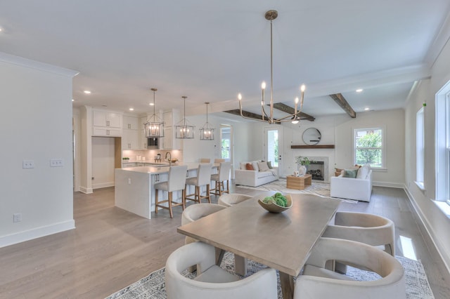 4025 Singing Creek Dr, Franklin, TN 37064 - dining room featuring light wood finished floors, a chandelier, recessed lighting, a fireplace, and beam ceiling