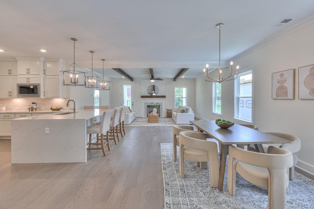 4025 Singing Creek Dr, Franklin, TN 37064 - dining room with a chandelier, a fireplace, light wood-type flooring, beamed ceiling, and recessed lighting