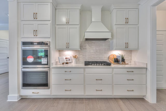 4025 Singing Creek Dr, Franklin, TN 37064 - kitchen with appliances with stainless steel finishes, light countertops, premium range hood, and light wood-style flooring