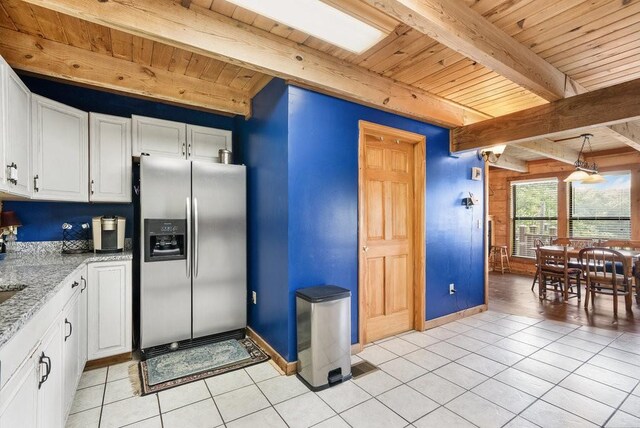 2875 Stage Coach Rd, Sewanee, TN 37375 - kitchen with stainless steel fridge, a wooden ceiling with exposed beams, light tile patterned flooring, white cabinets, and light stone countertops