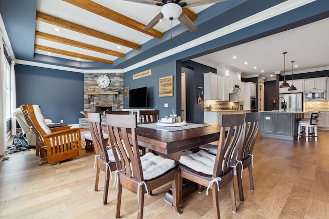 6013 Blackwell Ln, Franklin, TN 37064 - dining area featuring ceiling fan, a stone fireplace, light wood-style flooring, recessed lighting, and beam ceiling