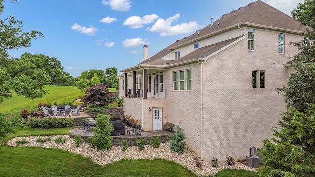 6013 Blackwell Ln, Franklin, TN 37064 - view of home's exterior featuring a patio area, a yard, brick siding, and a chimney
