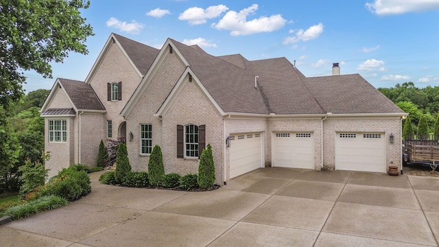 6013 Blackwell Ln, Franklin, TN 37064 - view of front of property featuring brick siding, concrete driveway, an attached garage, a chimney, and roof with shingles