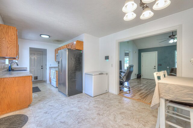 168 N Wagon Trl, Murfreesboro, TN 37128 - kitchen with white appliances, brown cabinets, light countertops, a chandelier, and ceiling fan