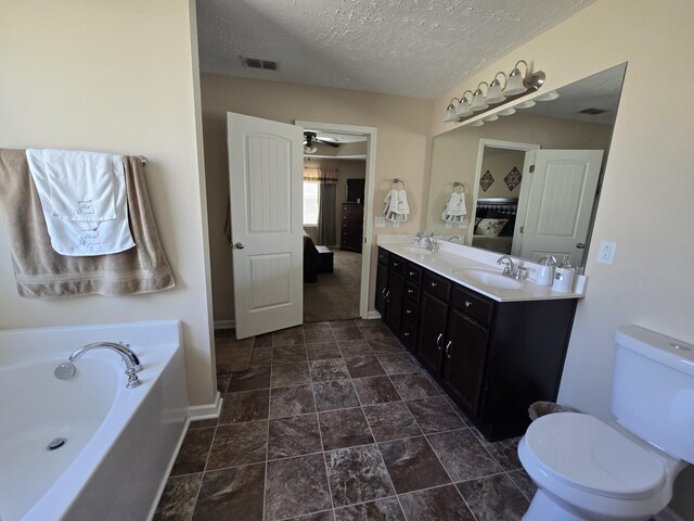 1736 Bellamy Ln, Murfreesboro, TN 37128 - ensuite bathroom featuring double vanity, a garden tub, a textured ceiling, and stone finish floors