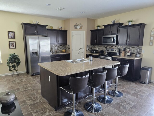 1736 Bellamy Ln, Murfreesboro, TN 37128 - kitchen featuring stainless steel appliances, an island with sink, tasteful backsplash, light countertops, and a kitchen bar