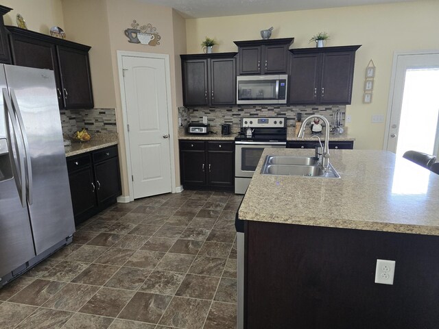 1736 Bellamy Ln, Murfreesboro, TN 37128 - kitchen featuring stainless steel appliances, backsplash, light countertops, dark stone finish floors, and an island with sink