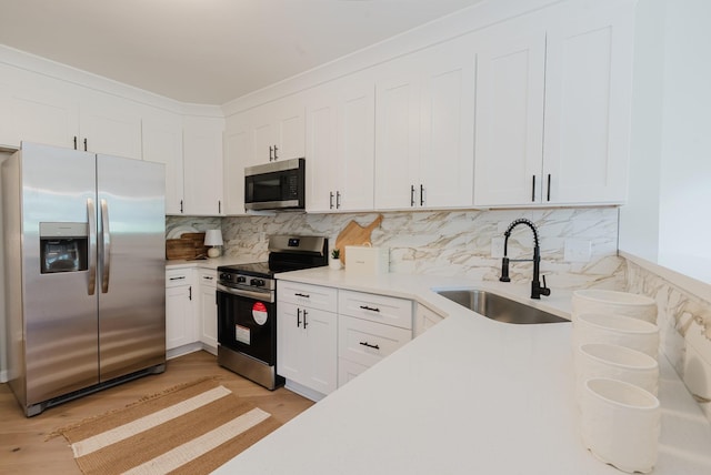 100 Crestfield Pl, Franklin, TN 37069 - kitchen featuring stainless steel appliances, white cabinetry, light countertops, tasteful backsplash, and light wood finished floors