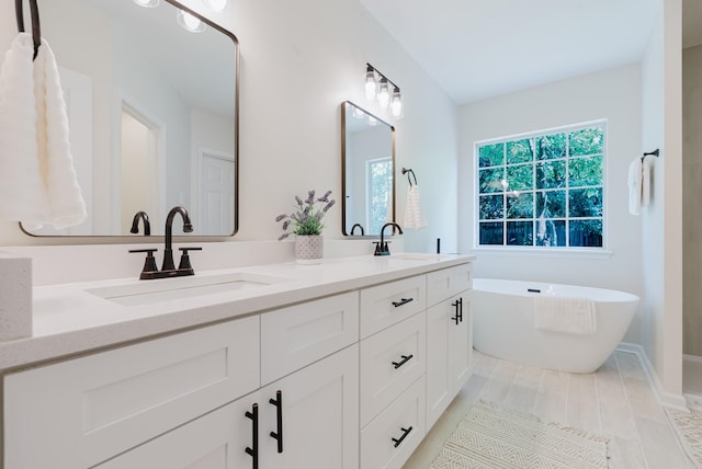 100 Crestfield Pl, Franklin, TN 37069 - bathroom featuring double vanity, a freestanding tub, and wood finished floors