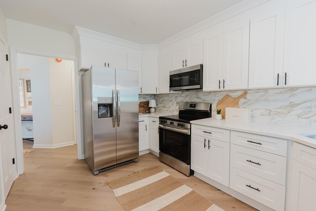 100 Crestfield Pl, Franklin, TN 37069 - kitchen featuring appliances with stainless steel finishes, decorative backsplash, white cabinetry, light countertops, and light wood-style floors