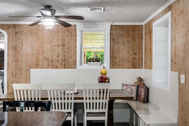 554 Hickman Shores Rd, Dover, TN 37058 - dining room with wooden walls, a textured ceiling, crown molding, and a ceiling fan
