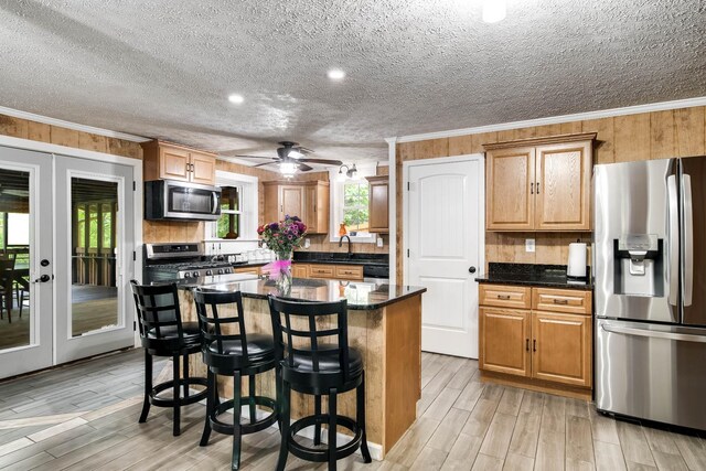 554 Hickman Shores Rd, Dover, TN 37058 - kitchen featuring stainless steel appliances, crown molding, light wood-style floors, a kitchen bar, and a kitchen island