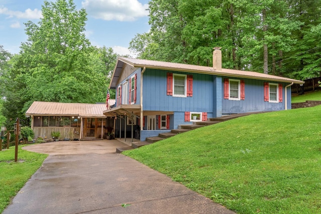554 Hickman Shores Rd, Dover, TN 37058 - view of front of house featuring concrete driveway, a front lawn, a chimney, and a metal roof