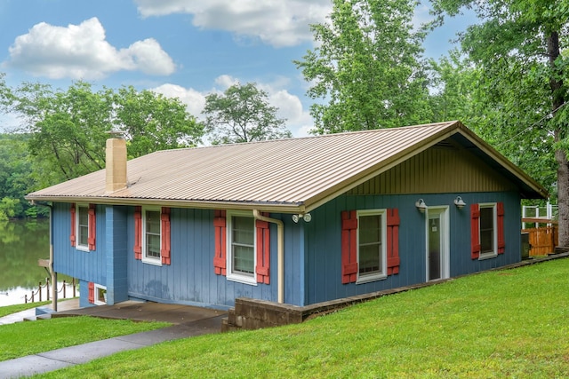 554 Hickman Shores Rd, Dover, TN 37058 - view of front of house featuring a metal roof, a chimney, and a front lawn