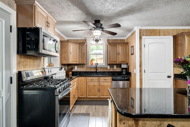554 Hickman Shores Rd, Dover, TN 37058 - kitchen with appliances with stainless steel finishes, light wood-type flooring, ornamental molding, ceiling fan, and dark stone countertops
