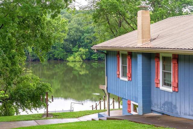 554 Hickman Shores Rd, Dover, TN 37058 - view of property exterior with a water view, a chimney, and a metal roof