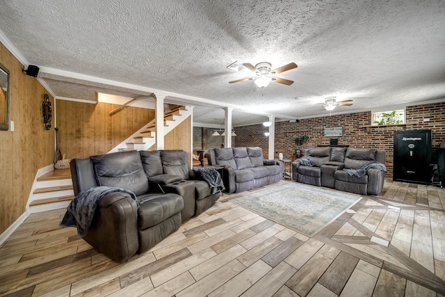 554 Hickman Shores Rd, Dover, TN 37058 - living room with wood finished floors, stairs, ceiling fan, brick wall, and a textured ceiling