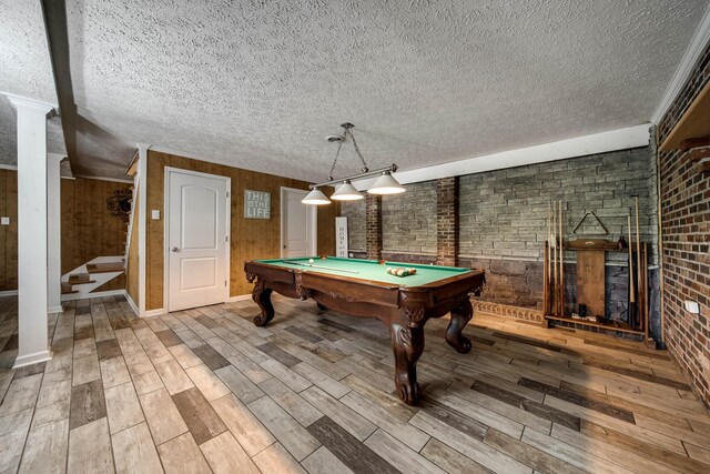 554 Hickman Shores Rd, Dover, TN 37058 - rec room featuring a textured ceiling, wood finished floors, pool table, brick wall, and a fireplace