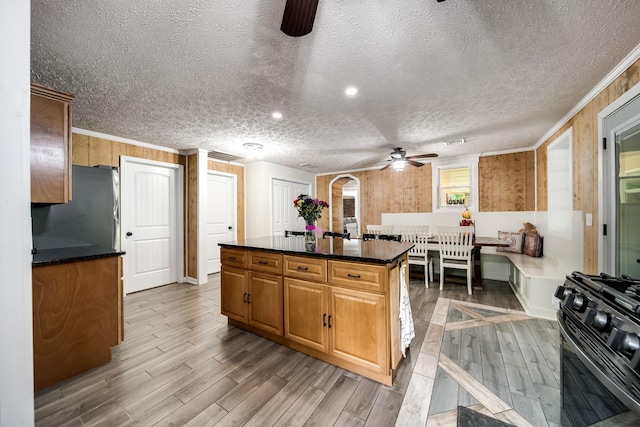 554 Hickman Shores Rd, Dover, TN 37058 - kitchen with stainless steel gas stove, ceiling fan, freestanding refrigerator, light wood-style floors, and dark countertops