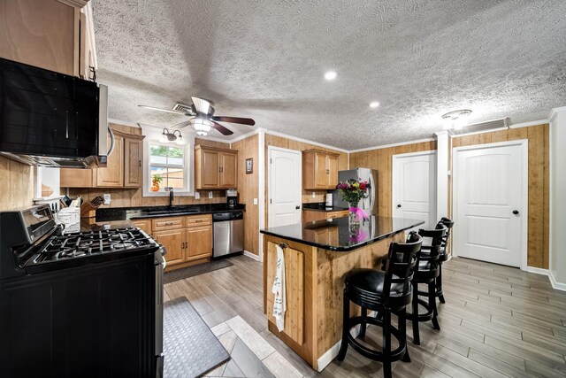 554 Hickman Shores Rd, Dover, TN 37058 - kitchen featuring stainless steel appliances, ornamental molding, a ceiling fan, dark countertops, and a kitchen island