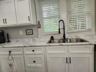 200 Church St, Loretto, TN 38469 - kitchen with white cabinets and light stone countertops