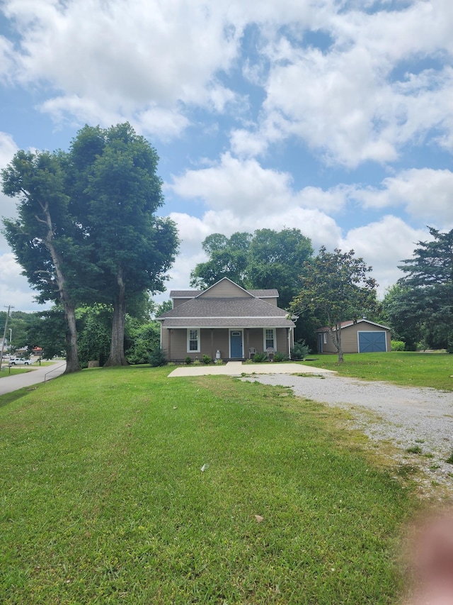 200 Church St, Loretto, TN 38469 - view of front facade with gravel driveway, a front yard, an outdoor structure, and a porch