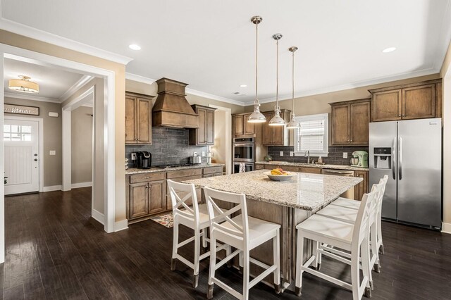 318 Finnhorse Ln, Franklin, TN 37064 - kitchen featuring stainless steel appliances, premium range hood, a center island, a kitchen bar, and decorative backsplash