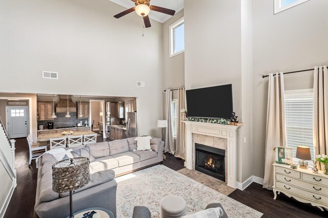 318 Finnhorse Ln, Franklin, TN 37064 - living area featuring a towering ceiling, a ceiling fan, a tile fireplace, dark wood-style flooring, and crown molding