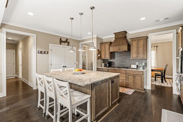 318 Finnhorse Ln, Franklin, TN 37064 - kitchen featuring custom range hood, a kitchen island, stainless steel appliances, brown cabinetry, and recessed lighting