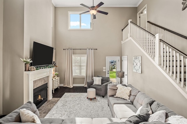 318 Finnhorse Ln, Franklin, TN 37064 - living area with a ceiling fan, a towering ceiling, dark wood-style floors, a fireplace with flush hearth, and crown molding