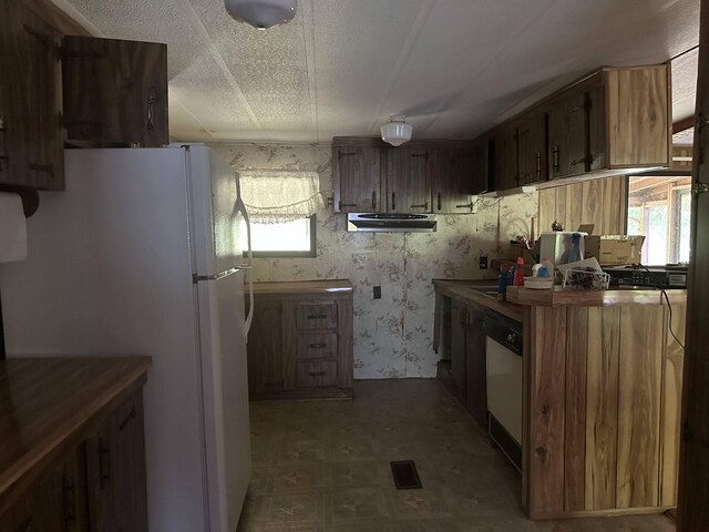 4719 Bogard Rd, Cosby, TN 37722 - kitchen featuring tile patterned floors, white appliances, under cabinet range hood, and brown cabinets