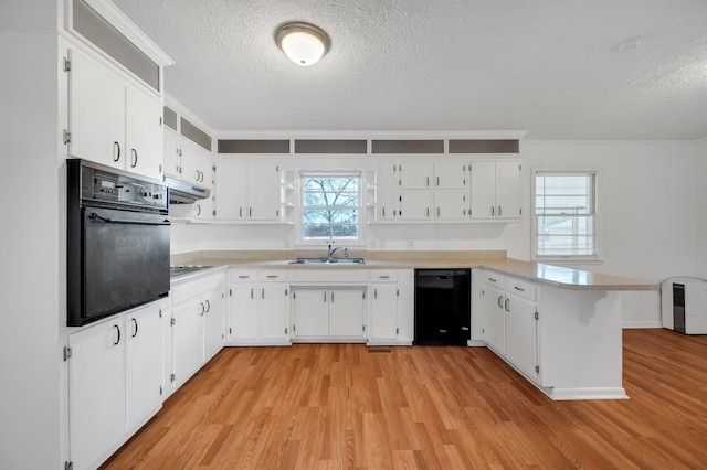 1077 Weeks Rd, Murfreesboro, TN 37127 - kitchen with black appliances, a textured ceiling, a peninsula, light wood finished floors, and light countertops