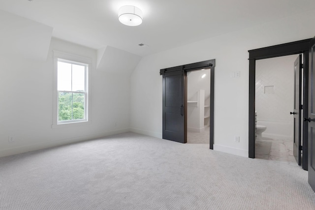 7312 Walker Rd, Fairview, TN 37062 - unfurnished bedroom featuring carpet flooring, a walk in closet, a barn door, and connected bathroom