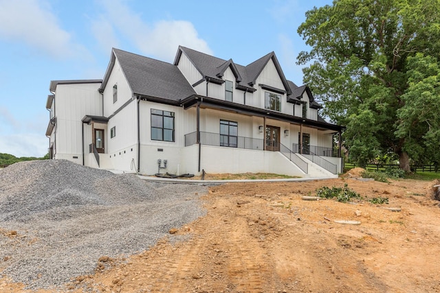 7312 Walker Rd, Fairview, TN 37062 - modern farmhouse style home with a porch, a shingled roof, stairway, board and batten siding, and gravel driveway