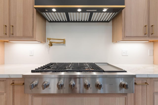 7312 Walker Rd, Fairview, TN 37062 - kitchen view of stainless steel gas cooktop, exhaust hood, light brown cabinets, and light stone counters