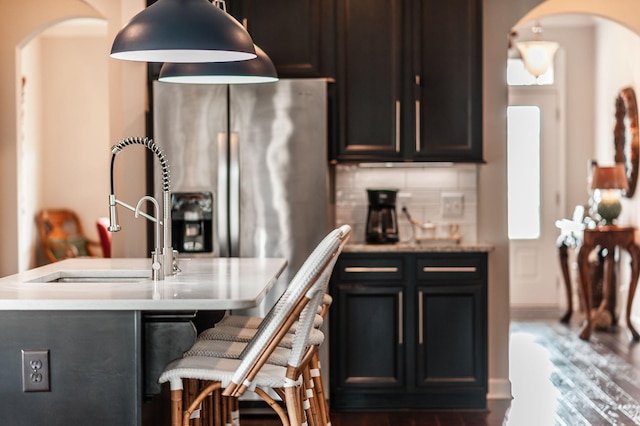 2044 Albatross Way, Gallatin, TN 37066 - kitchen with arched walkways, stainless steel fridge, wood finished floors, light countertops, and a kitchen bar