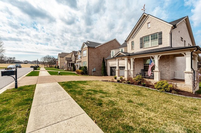 2044 Albatross Way, Gallatin, TN 37066 - view of home's exterior featuring brick siding, covered porch, a lawn, and a residential view