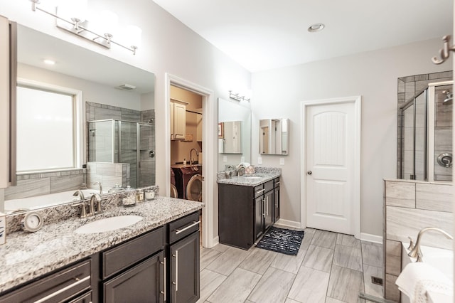 2044 Albatross Way, Gallatin, TN 37066 - full bathroom with two vanities, a stall shower, independent washer and dryer, and a garden tub