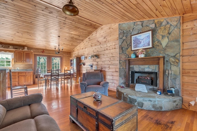 1010 Scott Rd, Bethpage, TN 37022 - living room featuring light wood-style floors, wood ceiling, wooden walls, lofted ceiling, and a stone fireplace